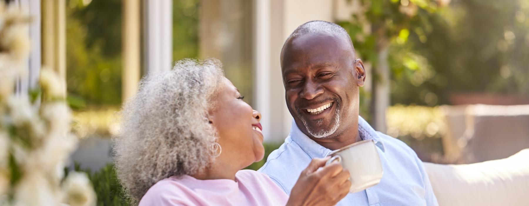 a man and a woman sitting down smiling at each other