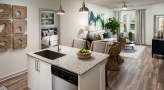 Spacious and well lit kitchen with stainless steel appliances and dark accents 