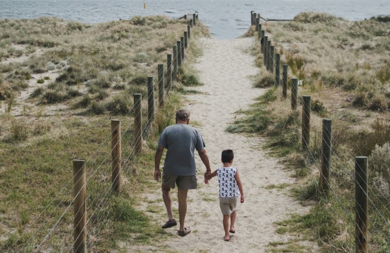 Two people walking down a beach