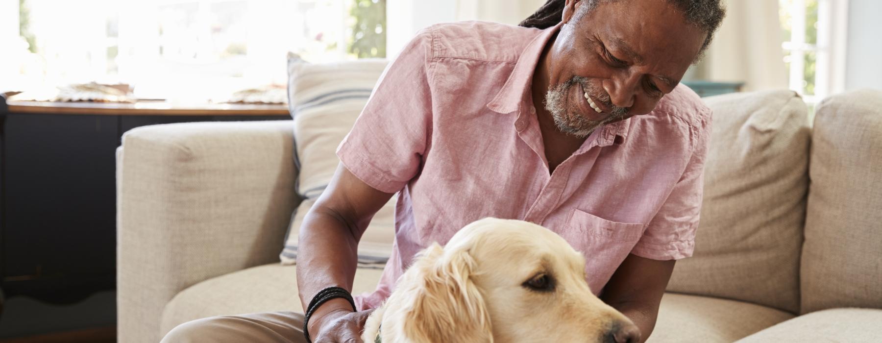 a man sitting on a couch with a dog