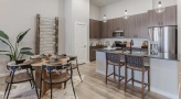 Spacious and well lit kitchen with stainless steel appliances and dark accents 