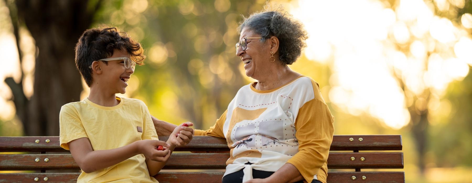 a woman and a boy sitting on a park bench