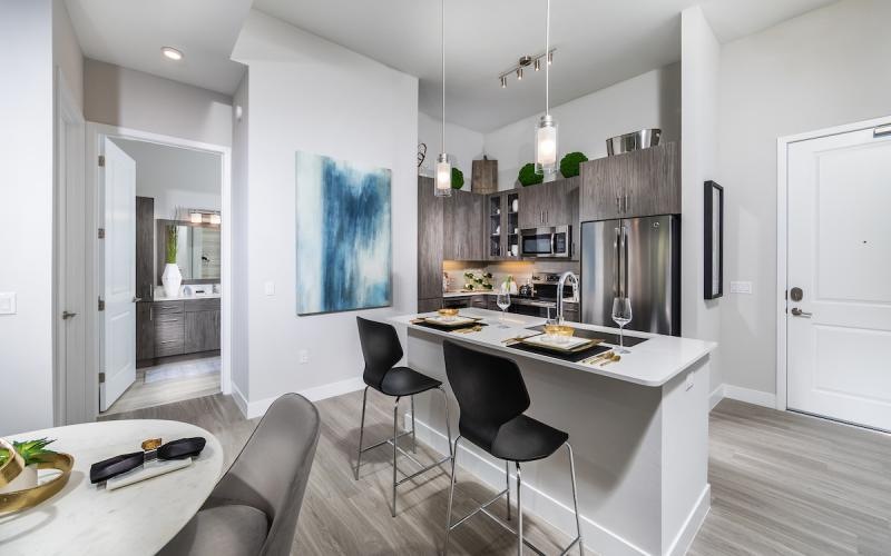 a kitchen with a bar and chairs