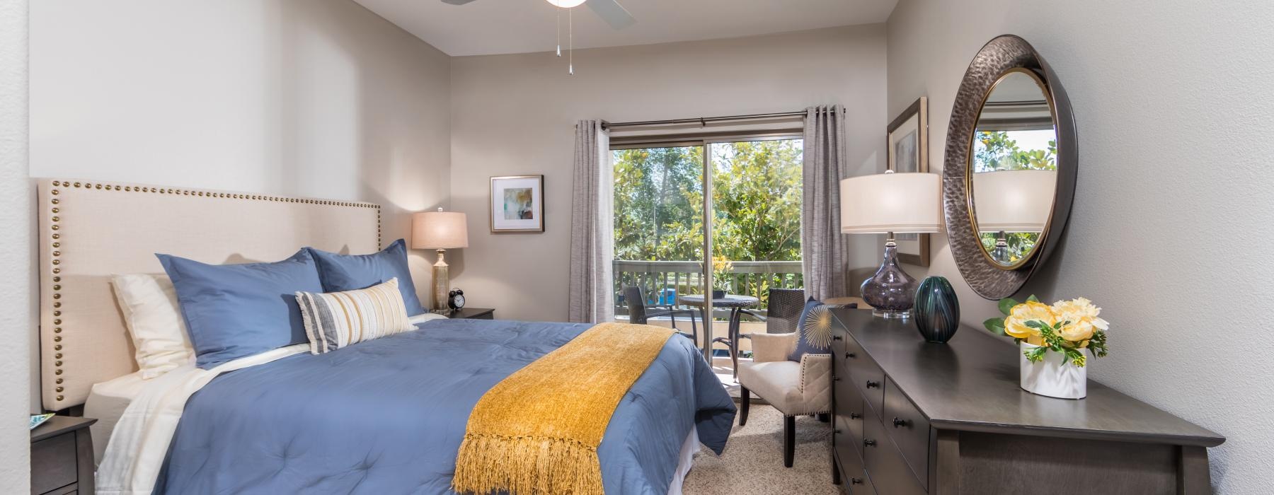 Large well lit bedroom with carpets and a large window