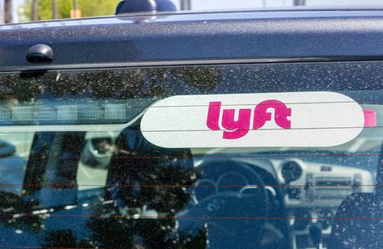 Image of a car's rear windshield with a Lyft sign.