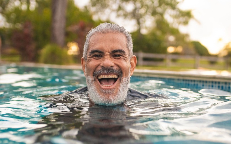 smiling man swimming in outdoor pool