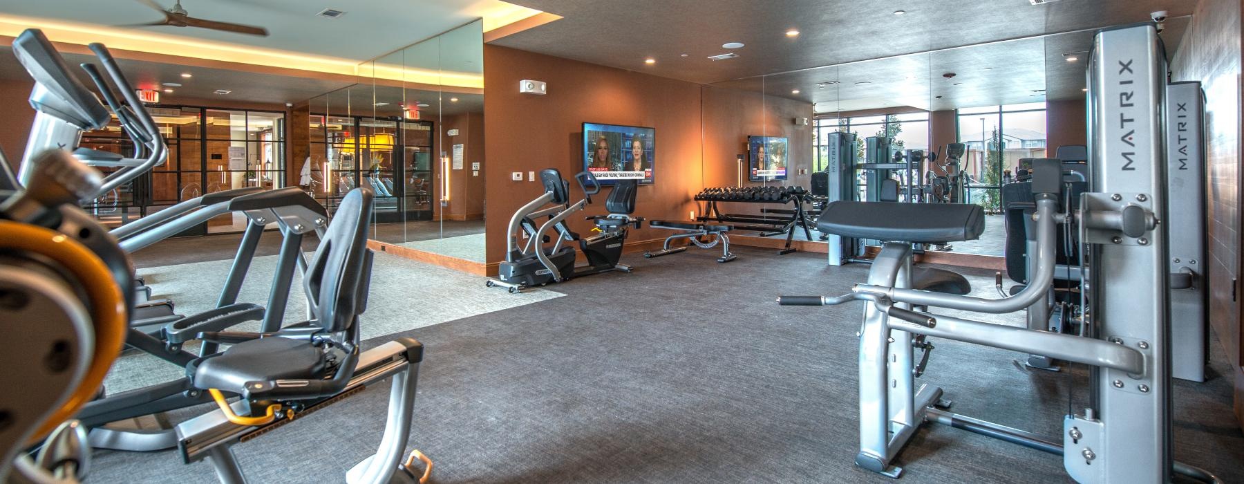 Large fitness center with large windows and plenty of equipment