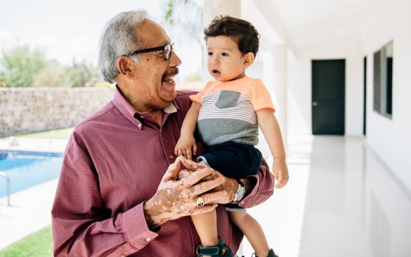 a man carrying a child smiling