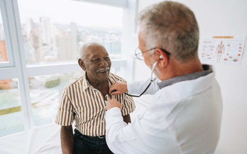 a doctor checking a older man's heart