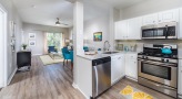 Spacious and well lit kitchen with stainless steel appliances and dark accents 