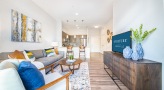 Spacious and well lit living room with wood floors and a large window