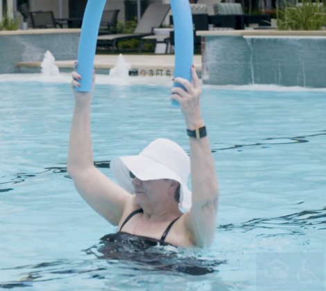 Senior woman in a pool doing exercise activities