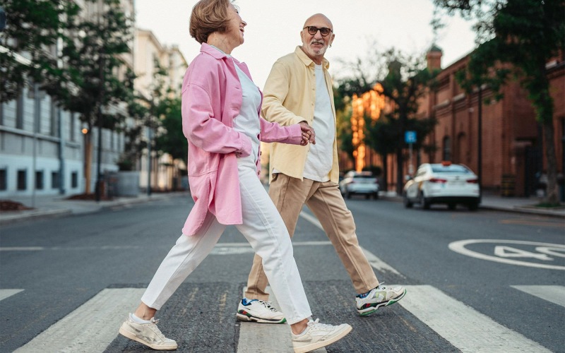 a man and woman walking across a street