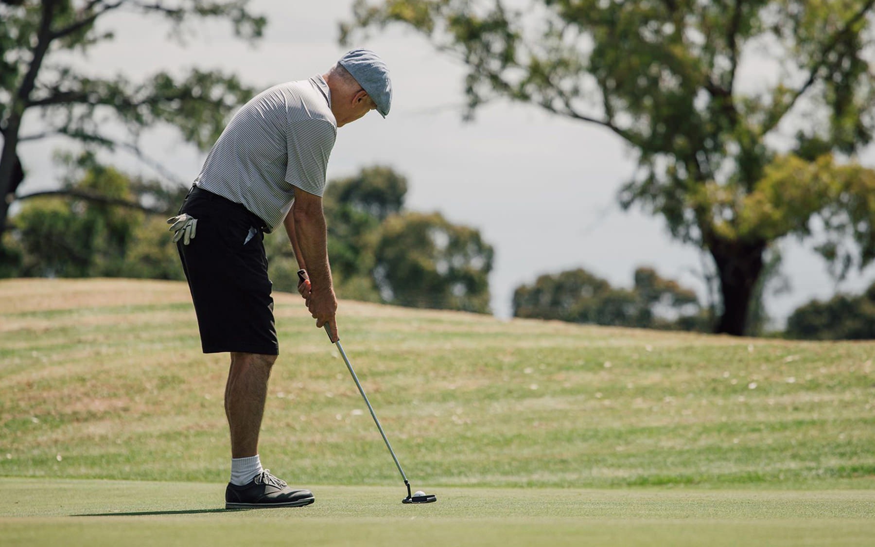 man on golf course putting a golf ball