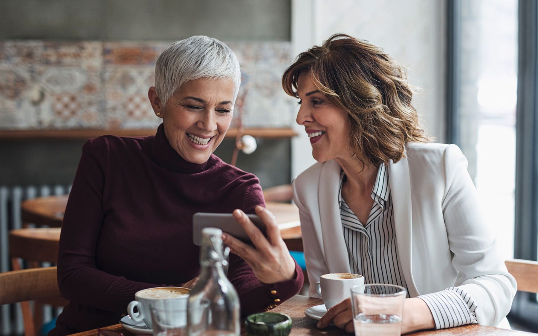 two women at a table drinking coffee