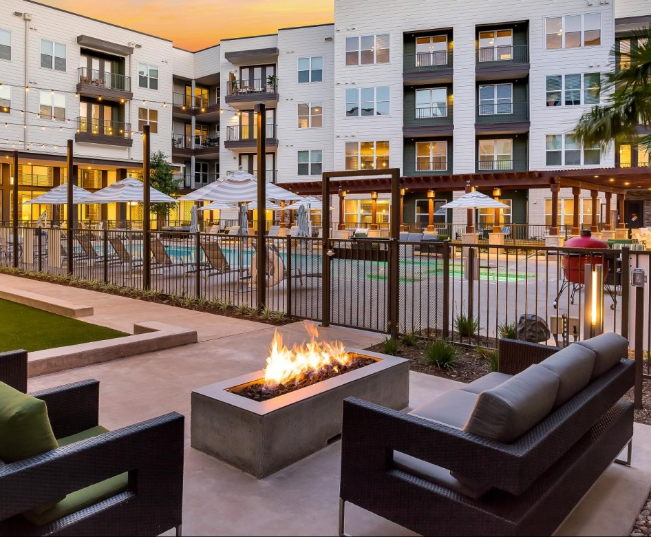 Large firepit next to a sparkling blue pool