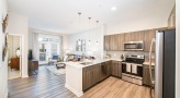 Spacious and well lit kitchen with stainless steel appliances and dark accents 