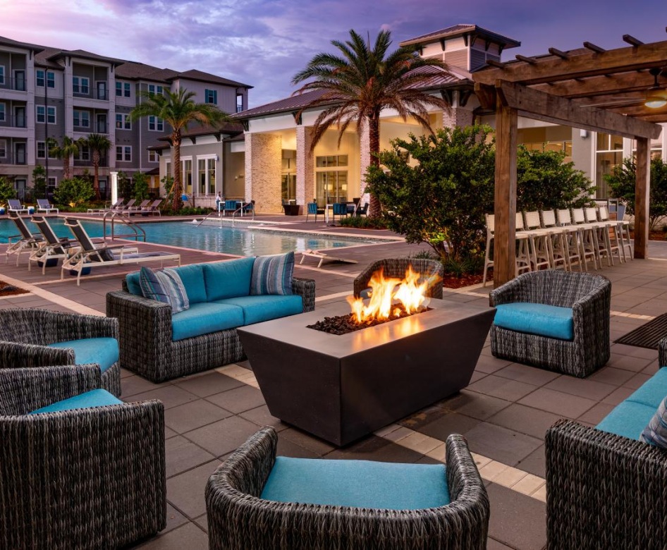 Large poolside patio with ample seating and a large fire pit