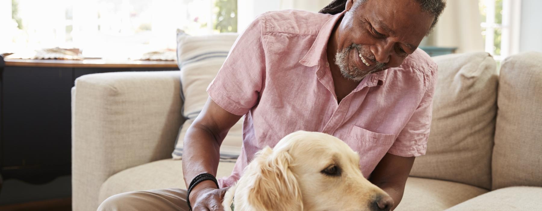 a man sitting on a couch with a dog