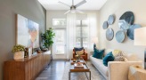 Spacious and well lit living room with wood floors and a large window