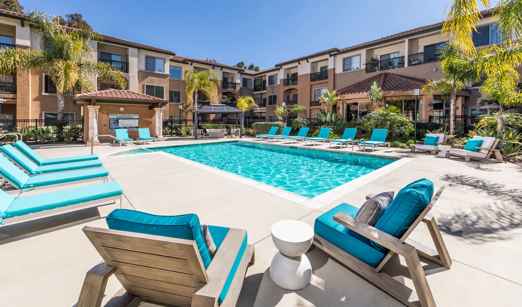 a pool with lounge chairs around it