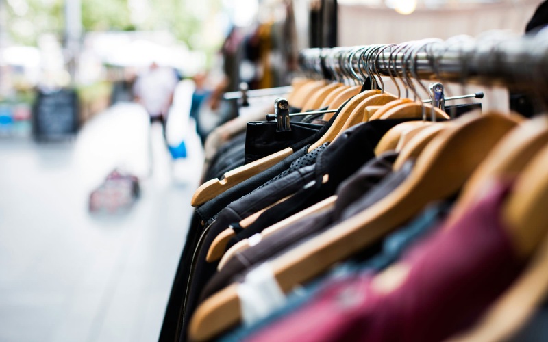 zoomed in photo focused on rack of clothes on hangers