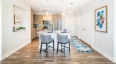 Spacious and well lit kitchen with stainless steel appliances and dark accents 