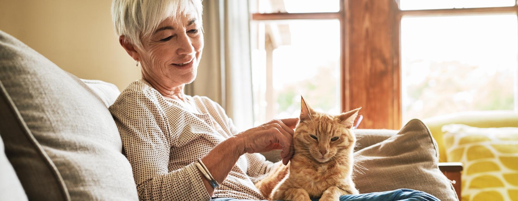 Woman sitting on her couch with her cat