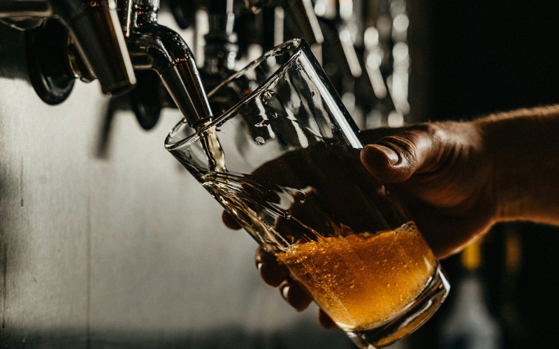 Hand filling beer glass from tap