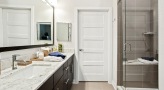 Large well lit bathroom with white accents 