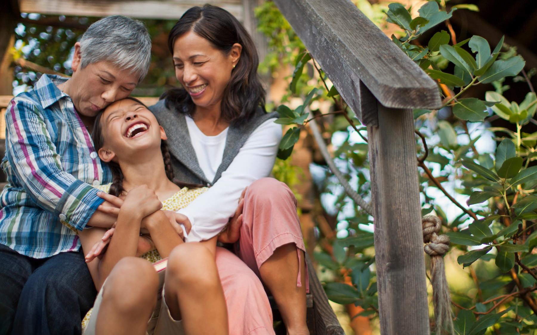 a child parent and grandparent embracing on stairs