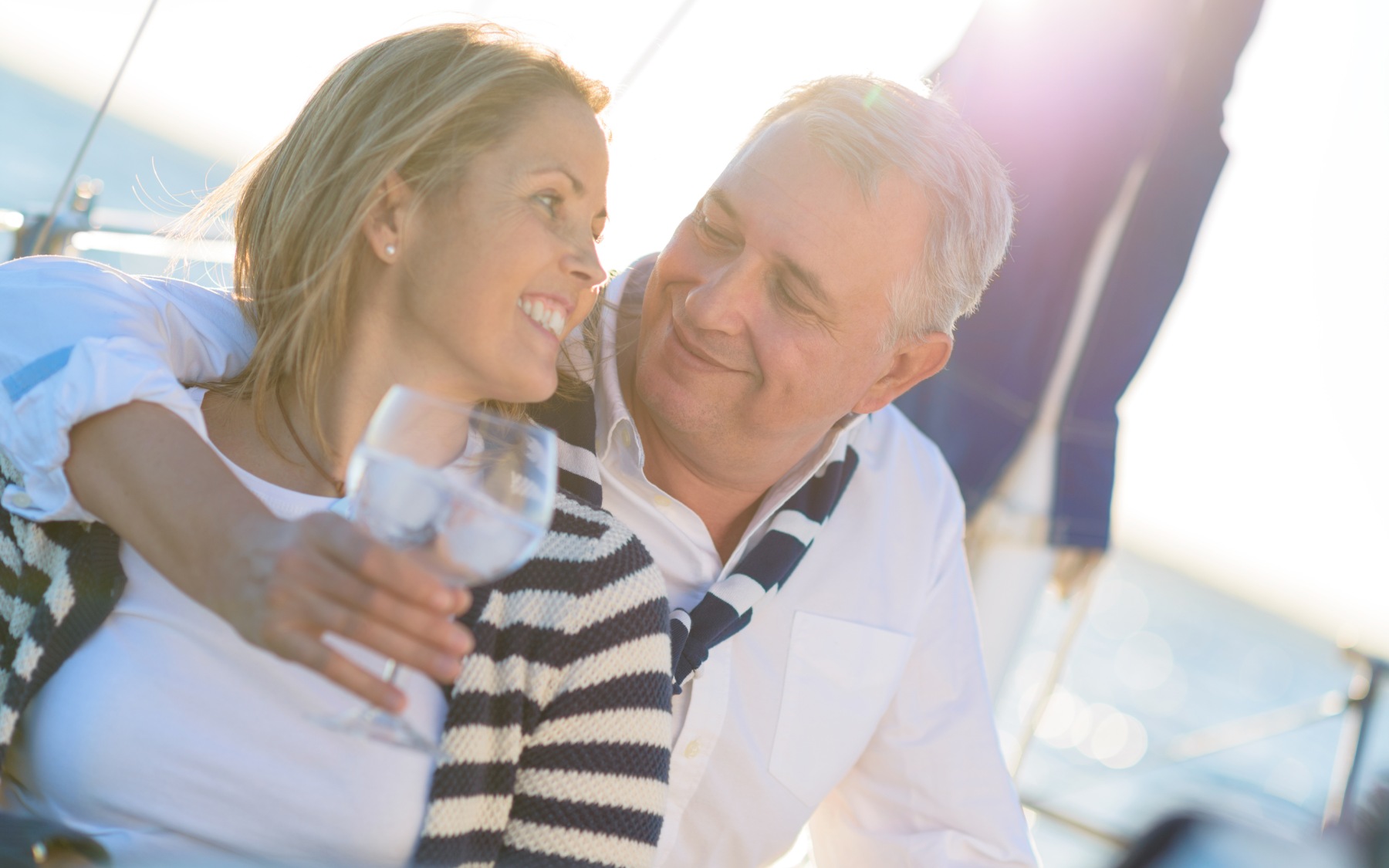 couple on a sail boat smiling at each other