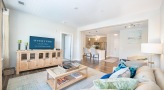 Spacious and well lit living room with wood floors and a large window