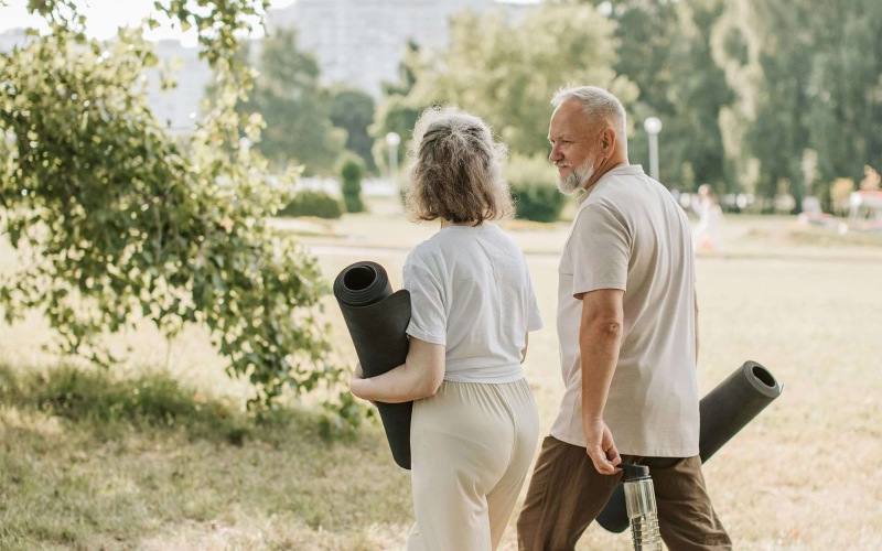 a man and woman walking with yoga mats