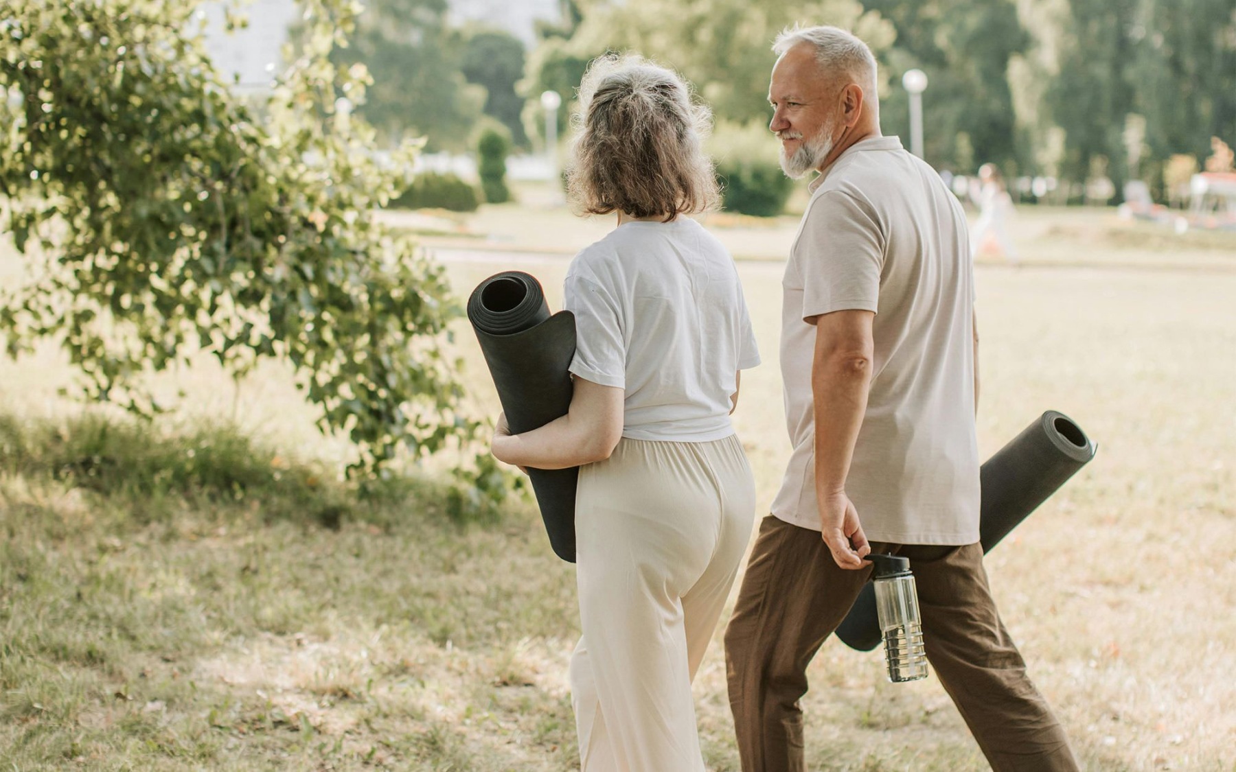 The essence of exceptional living a man and woman walking with yoga mats