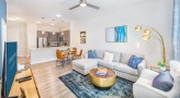 Spacious and well lit living room with wood floors and a large window