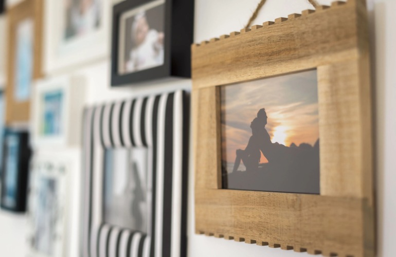 Close up of family pictures hanging on a wall.