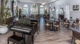 a room with a piano and tables and chaurs