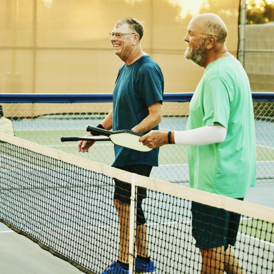 Your Wellness is Our Reason for Being two men on a pickleball court