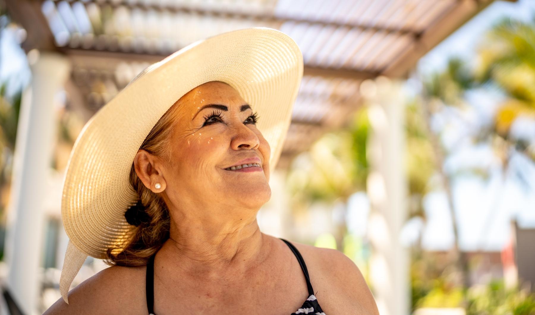 Lifestyle woman standing by the pool smiling