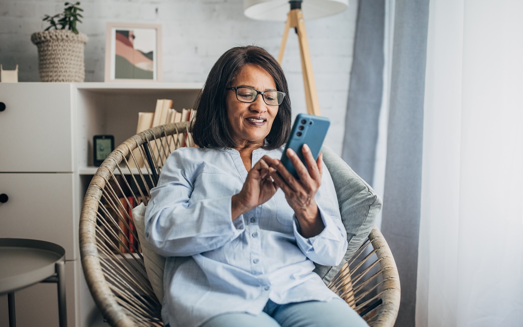 a woman sitting down looking at her cell phone