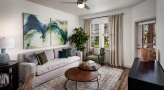 Spacious and well lit living room with wood floors and a large window