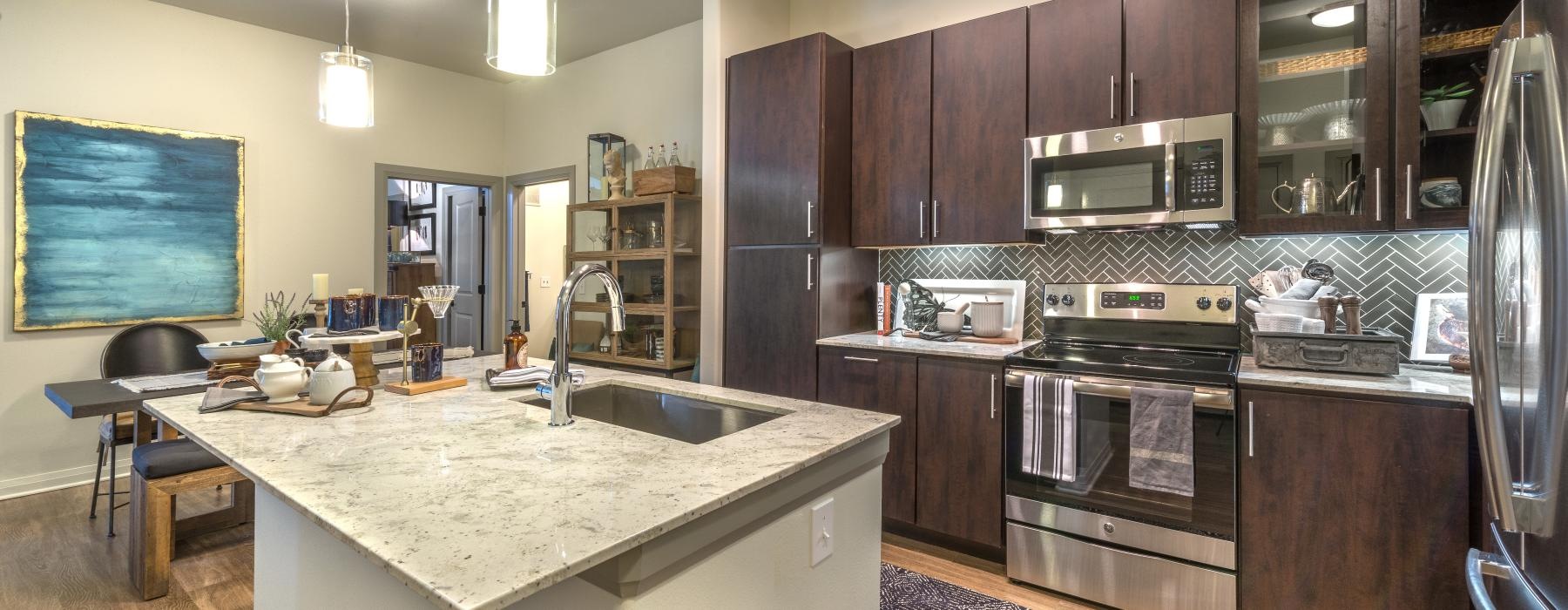 Spacious well lit kitchen with wood floors and stainless steel appliances