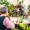 a group of people sitting at a table talking with a garden in the background